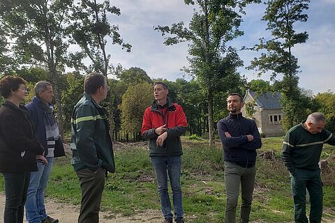Groupe de participants qui écoutent un guide de l'Office National des Forêts