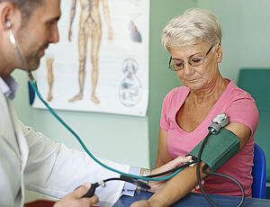 Un médecin prend la tension d'une femme sénior - Agrandir l'image (fenêtre modale)