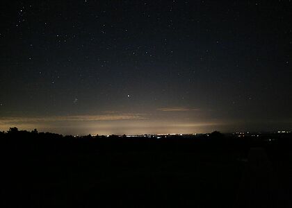 Ciel de nuit avec les lumières au loin